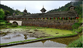 Une des portes d'entrées du village Dong de Huanggan, avec à côté le traditionnel pont du vent et de la pluie. Région de Congjiang. (5)