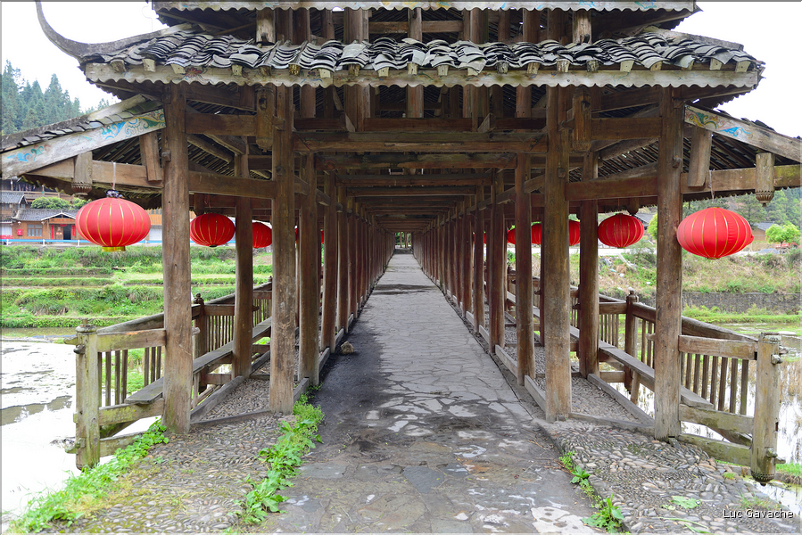 Une des portes d'entrées du village Dong de Huanggan, avec à côté le traditionnel pont du vent et de la pluie. Région de Congjiang. (6)