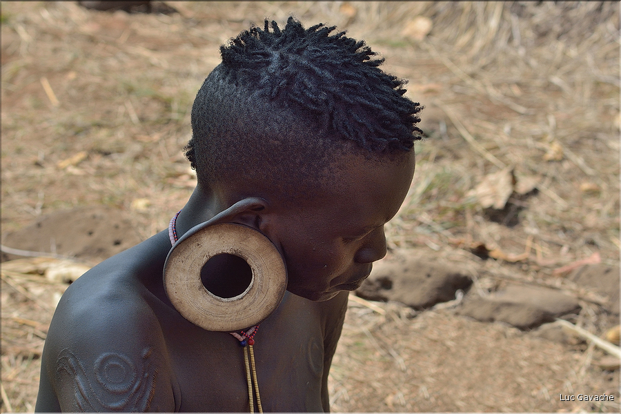 ..., elles se percent également les lobes d'oreille afin d'y insérer des disques de bois de plus en plus grands. (1)